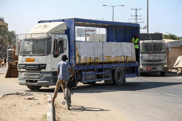 16 de outubro de 2025, Territórios Palestinos, Khan Yunis: Caminhões transportando ajuda alimentar e combustível, acompanhados por uma equipe das Nações Unidas, passaram pela passagem de fronteira de Kerem Shalom e chegaram à Faixa de Gaza em 16 de outubr