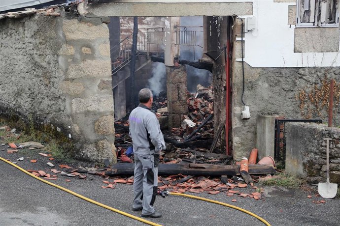 Una persona observa una casa calcinada, a 20 de septiembre de 2025, en Pantón, Lugo, Galicia (España).