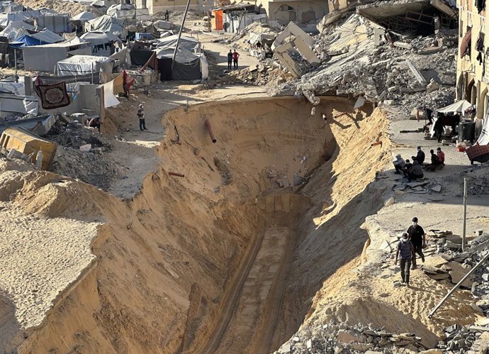 18 de outubro de 2025, Khan Yunis, Faixa de Gaza, Território Palestino: Palestinos usando escavadeiras cavam fundo no solo, supostamente à procura de corpos, em Khan Yunis, no sul da Faixa de Gaza, em 19 de outubro de 2025. O Hamas enfatizou que estava co