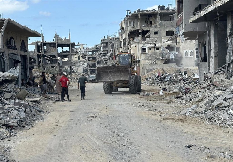 Palestinos en una calle de la ciudad de Jan Yunis después de la entrada en vigor del alto el fuego, entre edificios destruidos a causa de la ofensiva del Ejército de Israel contra la Franja de Gaza (archivo)