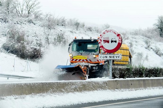 Archivo - Una máquina quitanieves aparta la nieve de una carretera en Cantabria
