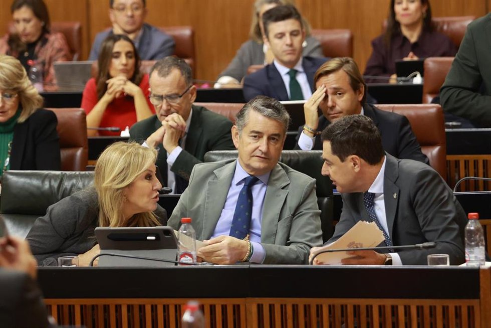 Archivo - El presidente de la Junta, Juanma Moreno (d), junto al consejero de la Presidencia, Antonio Sanz (c), y la consejera de Economía, Hacienda y Fondos Europeos, Carolina España, en el Parlamento. (Foto de archivo).