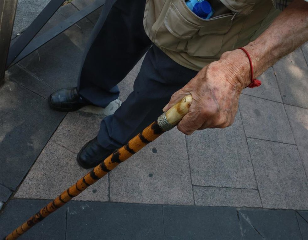 Archivo - Persona mayor caminando por la calle ayudada por un bastón, a 15 de julio de 2025, en Madrid (España).