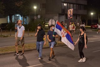 Archivo - 16 August 2025, Serbia, Belgrade: Protesters carry a Serbian flag in the street. during an anti-government protest in Belgrade. Demonstrators clashed with riot police in Belgrade as tear gas was used during days of anti-government protests. Phot