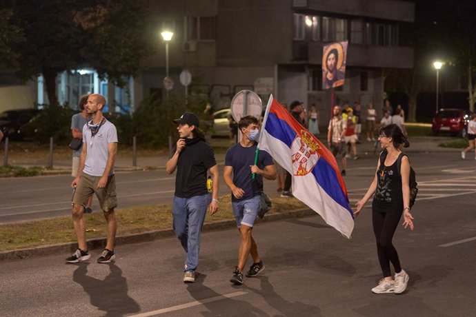 Archivo - 16 August 2025, Serbia, Belgrade: Protesters carry a Serbian flag in the street. during an anti-government protest in Belgrade. Demonstrators clashed with riot police in Belgrade as tear gas was used during days of anti-government protests. Phot