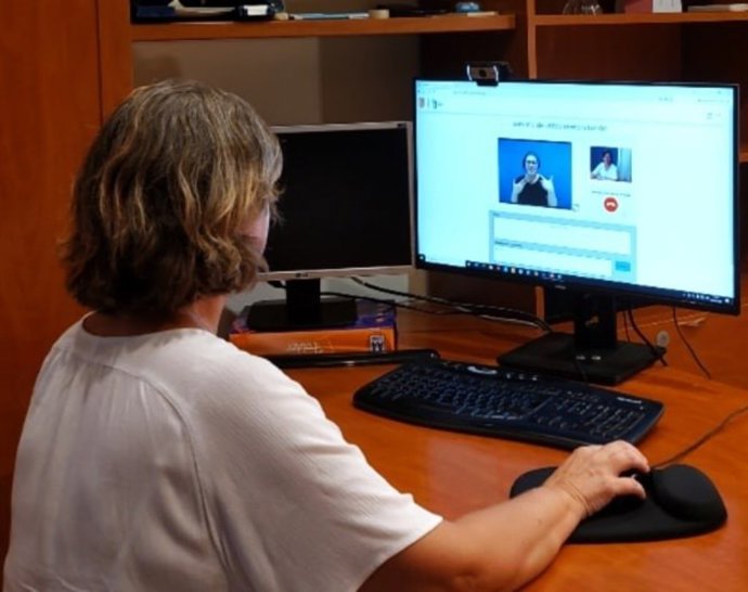 Una mujer contacta con una interprete de lenguaje de signos a través de una videollamada.