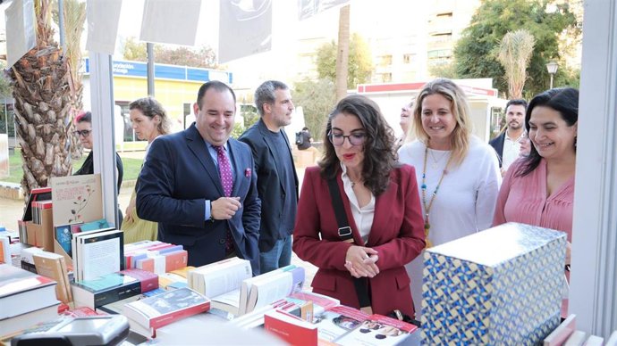 La delegada de Turismo y Cultura, Angie Moreno, acompañada por el director de la Feria, Antonio Agredano, en su visita a la Feria del Libro de Sevilla 2025.