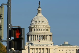 WASHINGTON, Oct. 22, 2025  -- This photo taken on Oct. 21, 2025 shows the U.S. Capitol building behind a traffic light in Washington, D.C., the United States.   The federal government shutdown entered its 21st day on Tuesday.