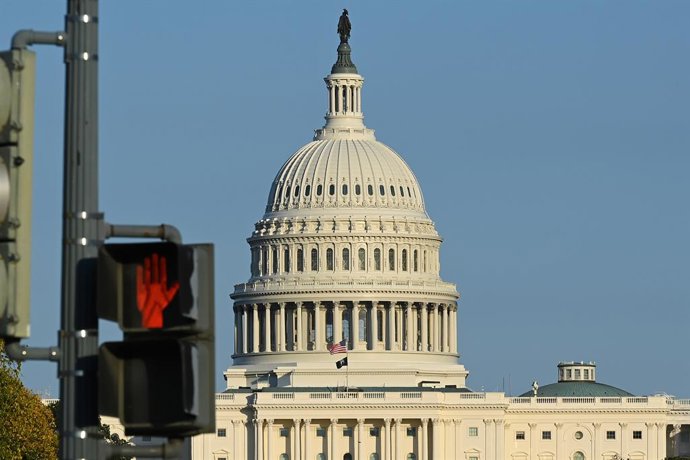 WASHINGTON, 22 de outubro de 2025 -- Esta foto tirada em 21 de outubro de 2025 mostra o edifício do Capitólio dos EUA atrás de um semáforo em Washington, D.C., Estados Unidos.   A paralisação do governo federal entrou em seu 21º dia na terça-feira.
