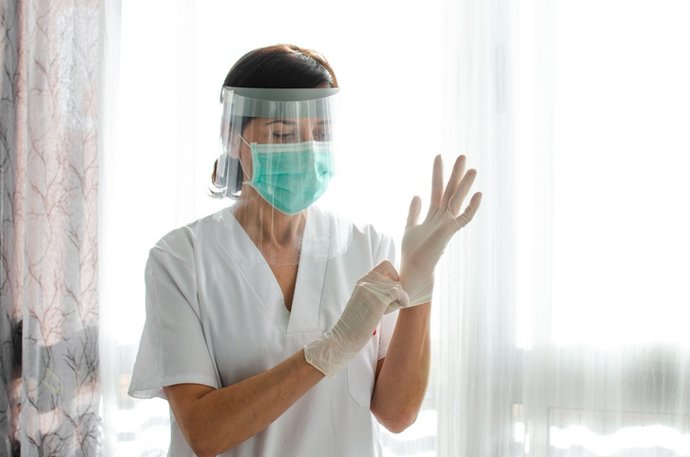 Archivo - Imagen de recurso de una enfermera poniéndose los guantes.