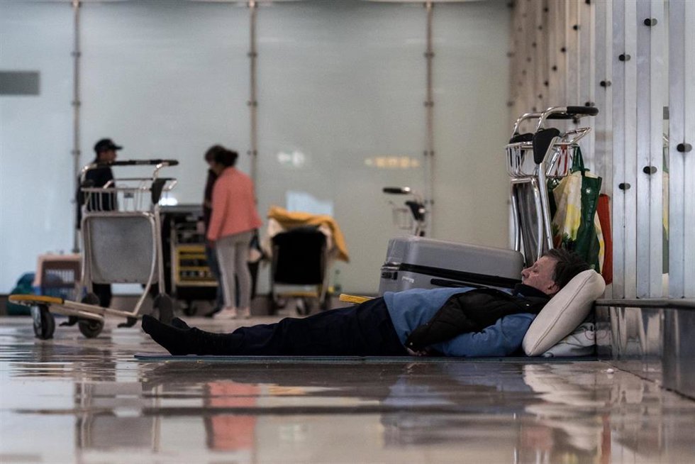 Archivo - Un hombre tumbado en el suelo en la T4 del Aeropuerto Adolfo Suárez-Madrid Barajas, a 12 de mayo de 2025, en Madrid (España).