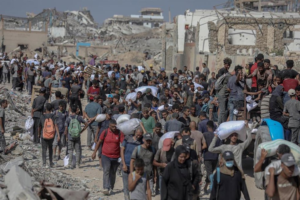 Archivo - Imagen de archivo de palestinos en Gaza cargando con ayuda humanitaria.