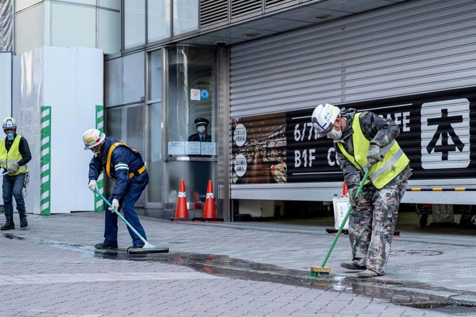 Archivo - 04 April 2020, Japan, Tokyo: Workers clean the street wearing face masks as a preventive measure, during the coronavirus pandemic. Photo: Viola Kam/SOPA Images via ZUMA Wire/dpa