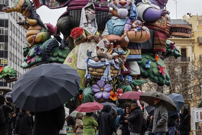 Archivo - Varias personas con paraguas durante el montaje de la Falla del Ayuntamiento, a 14 de marzo de 2025