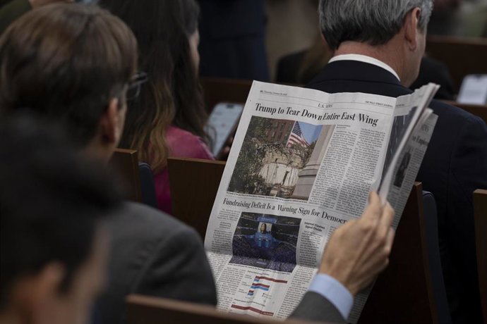 Un periodista lee sobre la demolición el Ala Este de la Casa Blanca durante una rueda de prensa en la residencia presidencial 