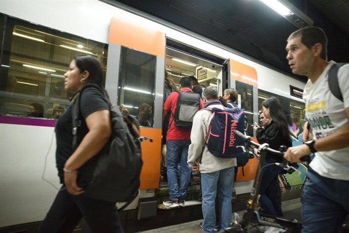 Archivo - Pasajeros subiendo al tren de Renfe Rodalies