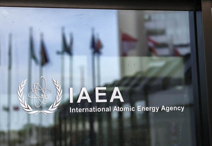 Archivo - June 4, 2025, Vienna, Austria, Austria: Glass doors at the entrance to the International Atomic Energy Agency (IAEA) headquarters reflect the row of member state flags outside the Vienna International Centre in Austria.