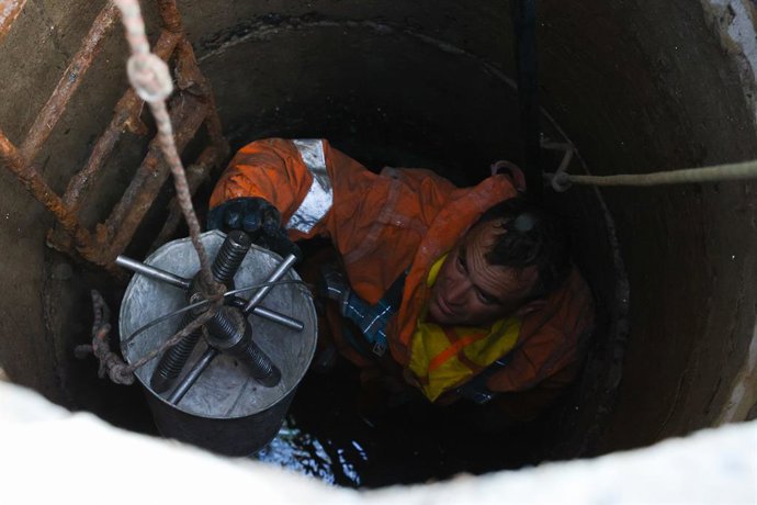 Archivo - RÚSSIA, BÉLGORODO - 3 de setembro de 2025: Trabalhadores de serviços públicos limpam canos de drenagem de águas superficiais