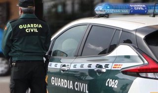 Un agente de la Guardia Civil junto a un vehículo oficial. Imagen de archivo.