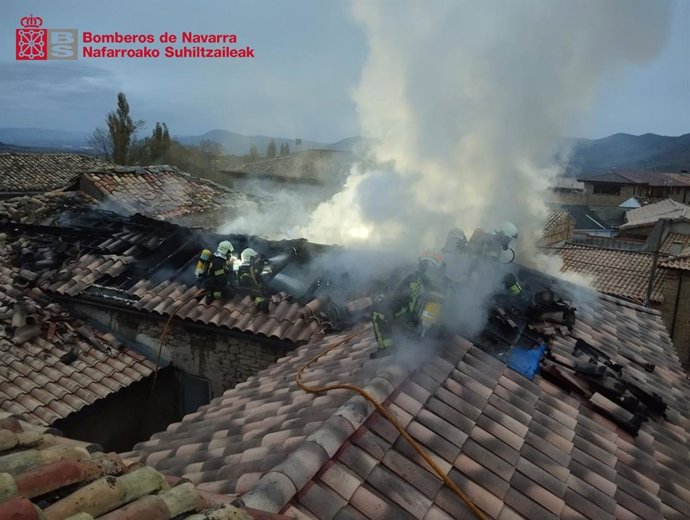 Los bomberos trabajan para extinguir el incendio de chimenea en una vivienda en Lerga.