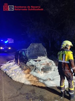 Un bombero junto al vehículo accidentado.