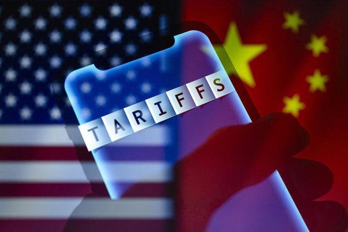 Archivo - Banderas de Estados Unidos y China tras una pantalla con la palabra 'tariffs', aranceles