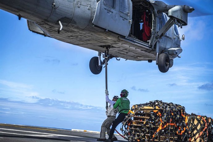 Archivo - Colocación de carga en un helicóptero 'MH-60S Sea Hawk' a bordo del portaaeronaves de Estados Unidos 'USS Nimitz' en el océano Pacífico (archivo)