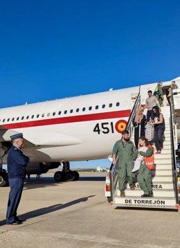 Los equipos médicos saliendo del avión junto a los pacientes y acompañantes evacuados.