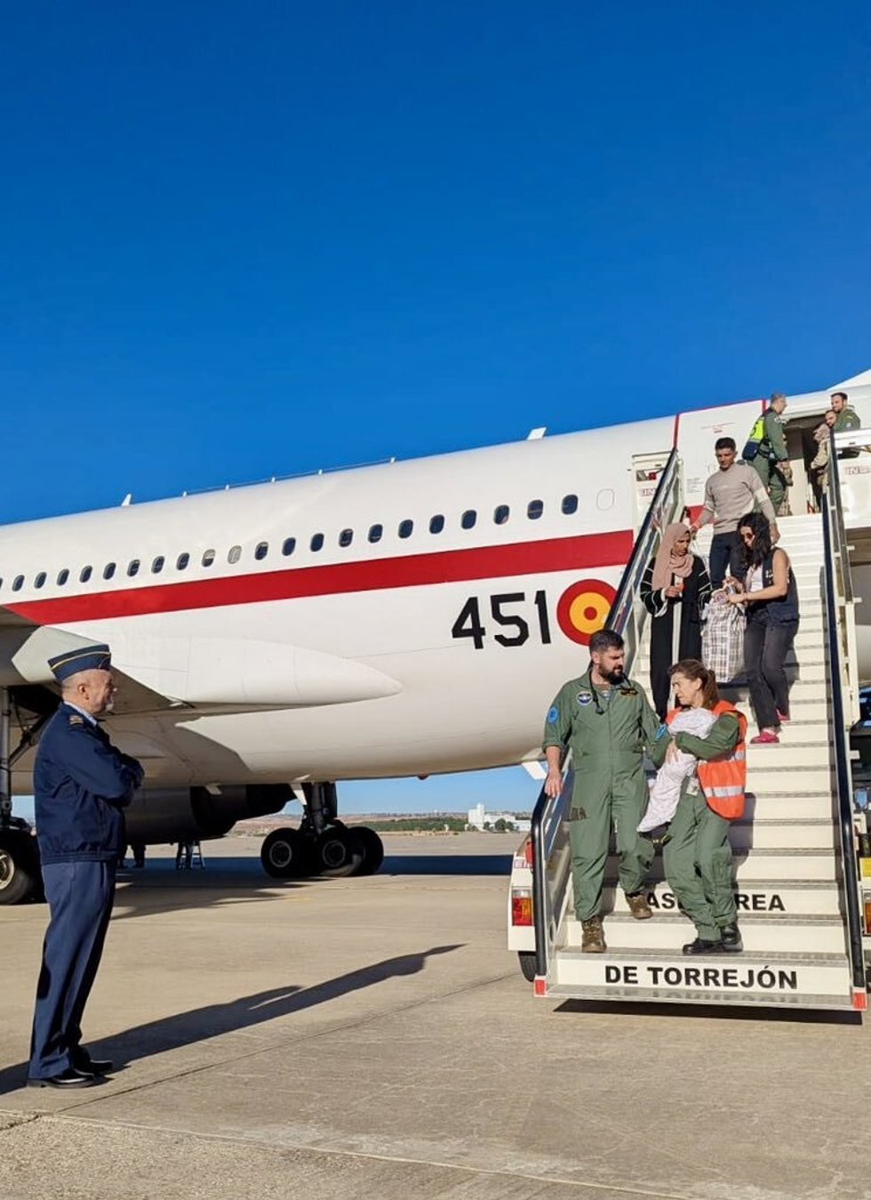 Los equipos médicos saliendo del avión junto a los pacientes y acompañantes evacuados.