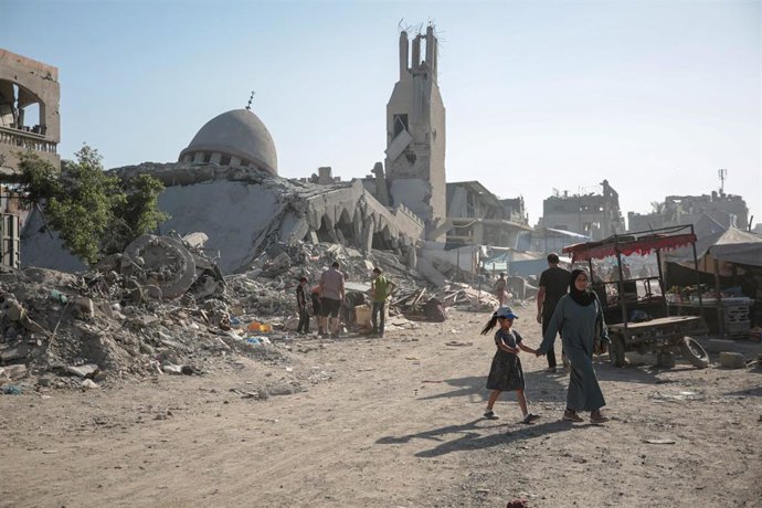 Palestinos entre edificios destruidos en Yabalia a causa de la ofensiva militar de Israel contra la Franja de Gaza tras los ataques del 7 de octubre de 2023 (archivo)