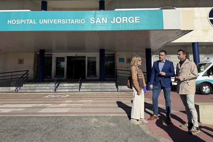El portavoz de Sanidad del PSOE en las Cortes de Aragón, Iván Carpi, junto a compañeros de partido, junto a la entrada al Hospital San Jorge de Huesca.