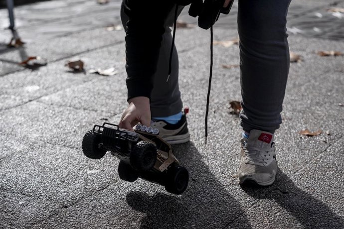 Archivo - Un niño juega con un coche teledirigido.