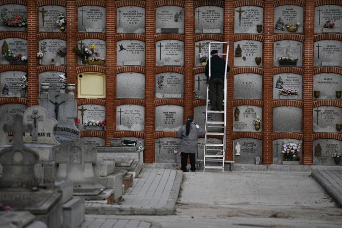 Archivo - Dos personas en el cementerio de La Almudena.