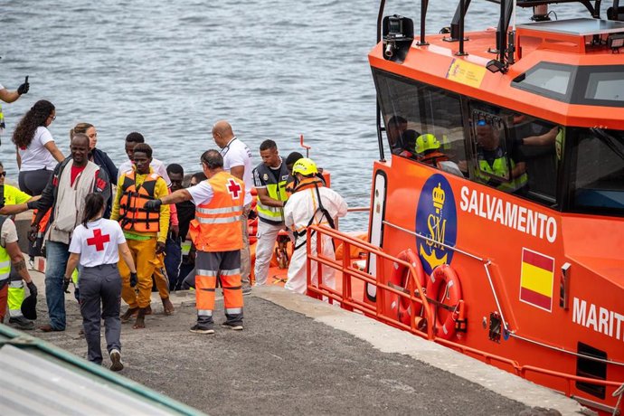 Varias personas salen de un cayuco, en el muelle de La Restinga