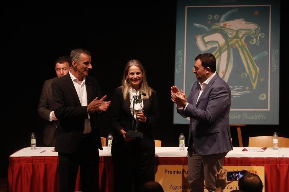 El presidente de Asturias, Adrián Barbón (dcha.), y el presidente de la Fundación Emilio Barbón,  José Vicente Barbón Fernández, entregan el galardón a la directora ejecutiva en España de UNRWA, Raquel Martí.