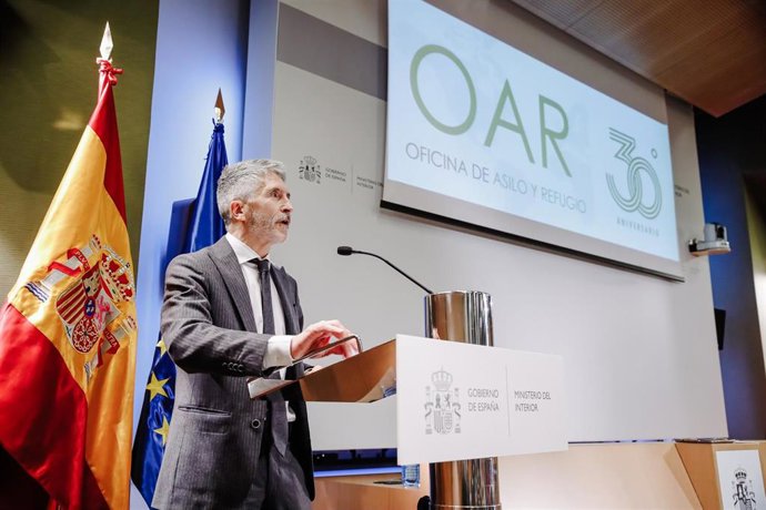Archivo - El ministro de Interior, Fernando Grande-Marlaska, interviene tras entregar la cruz al Mérito policial con distintivo blanco a la Oficina de Asilo y Refugio (OAR)
