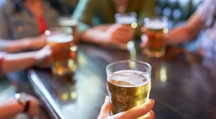 Varias personas toman cerveza.