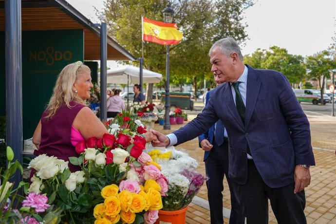 El alcalde de Sevilla visita uno de los quioscos de flores a la entrada del camposanto sevillano.