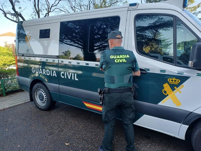 Archivo - Imagen de una furgoneta y un agente de la Guardia Civil.
