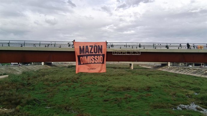 Las juventudes de Compromís despliegan una pancarta en el Pont de la Solidaritat exigiendo la dimisión de Mazón
