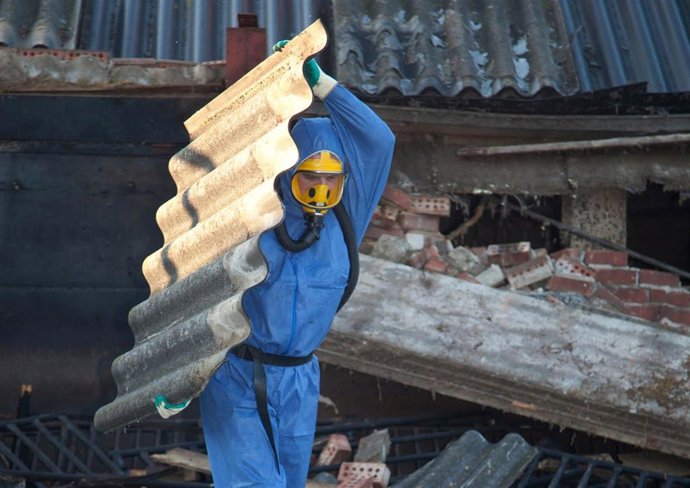 Archivo - Un operario retira una estructura de amianto.