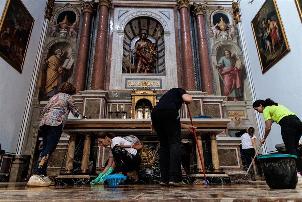 Archivo - Varias personas trabajan en una iglesia afectada por la dana el pasado noviembre en Chiva