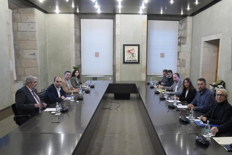 En el lado izquierdo, el secretario general de Gobiernos Locales y Relaciones con Aran, Xavier Amor (2d); y el conseller de Presidencia, Albert Dalmau (2i), se reúnen con representantes de la Associació Catalana de Municipis (ACM), la Federació de Munic