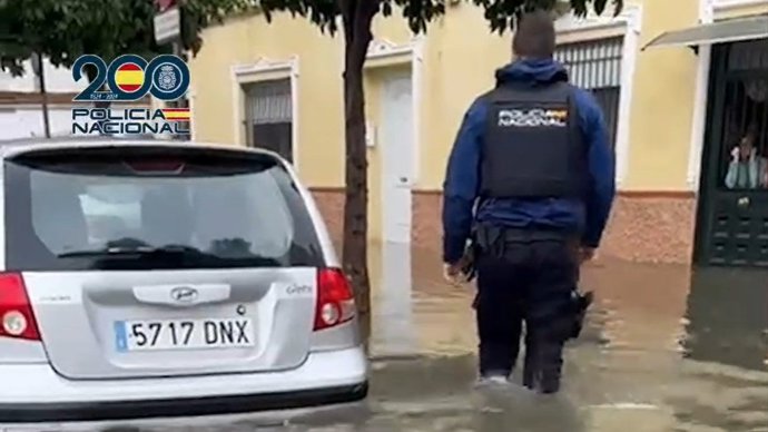 Imagen de un agente de la Policía Nacional durante las fuertes precipitaciones en Sevilla.