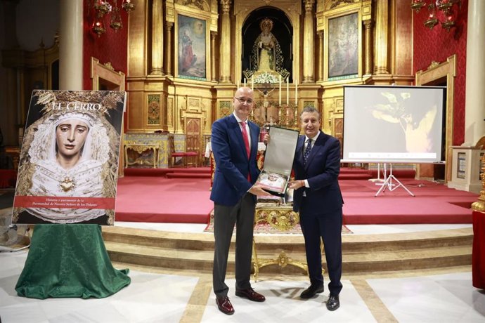 El presidente de la Diputación de Sevilla, Javier Fernández, hace entrega del libro sobre la hermandad del Cerro del Águila al hermano mayor de la corporación