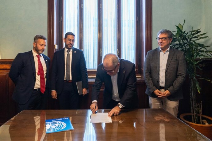El teniente de alcalde de Economía, Vivienda, Hacienda y Turismo del Ayuntamiento de Barcelona, Jordi Valls, firmando el acuerdo este jueves en un acto junto a los coordinadores de Open Source United de la ONU, Omar Mohsine y Mostafa Elkordy