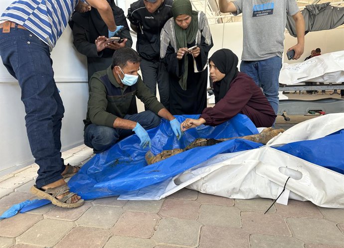 18 de outubro de 2025, Khan Yunis, Faixa de Gaza, Território Palestino: Famílias palestinas recebem os corpos de seus parentes, identificados após terem sido entregues pelo exército israelense ao Comitê Internacional da Cruz Vermelha (CICV) no Hospital Na