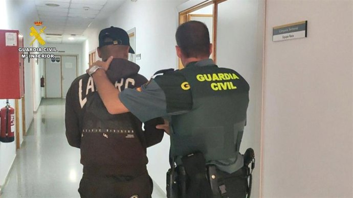 Un agente de la Guardia Civil custodia a un detenido.