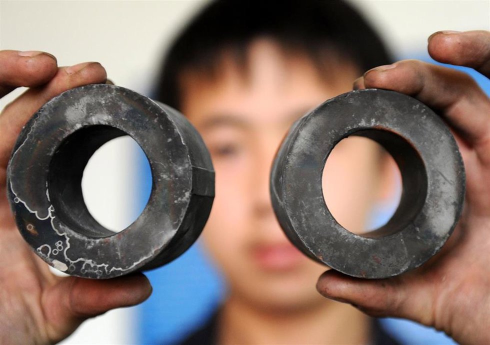 Archivo - Un empleado de una fábrica china muestra materiales combinados de hierro, rubidio y boron 