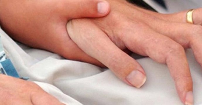 Imagen de archivo de una persona dándole la mano a otra.